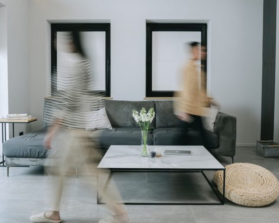 A stylish living room with minimalist decor featuring people in motion blur, creating dynamic energy.